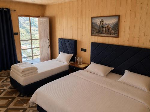 a hotel room with two beds and a window at Harshil Pinewood Homestay in Harsil