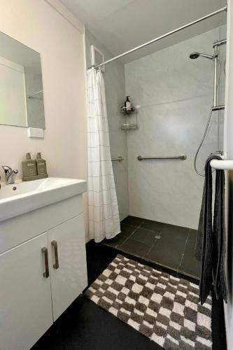 a white bathroom with a shower and a sink at The Jetty Hut - Lake Frontage Barmera Riverland in Barmera