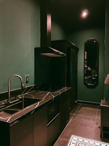 a black kitchen with a sink and a counter at G'Villa Thảo Điền in Ho Chi Minh City