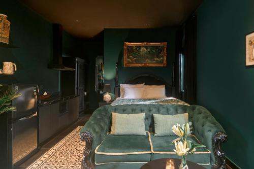 a green bedroom with a bed and a couch at G'Villa Thảo Điền in Ho Chi Minh City