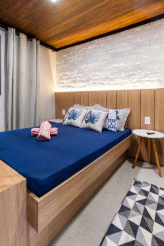 a bedroom with a bed with blue sheets and pillows at Studio Completo AC Piscina Pet Friendly NH in Novo Hamburgo