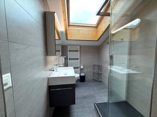 a bathroom with a sink and a shower and a skylight at Diana 9 in Leukerbad