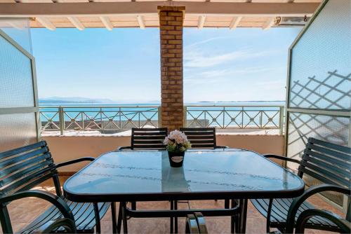 a table with a vase of flowers on a balcony at Ionelia Hospitality Apartments in Ipsos