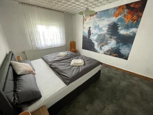 a bedroom with a bed and a painting on the wall at Ferienhaus Weitblick in Masserberg