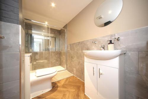 a bathroom with a sink and a toilet and a shower at Bedford Retreat in Bedford