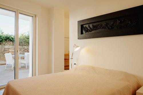 a bedroom with a bed and a view of a patio at Venti D'Amare Suites in Polignano a Mare