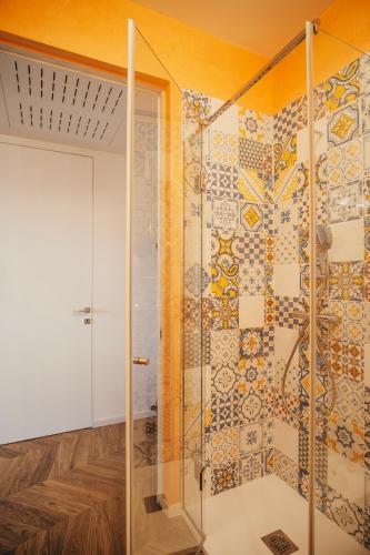 a bathroom with a shower with a mosaic wall at Venti D'Amare Suites in Polignano a Mare