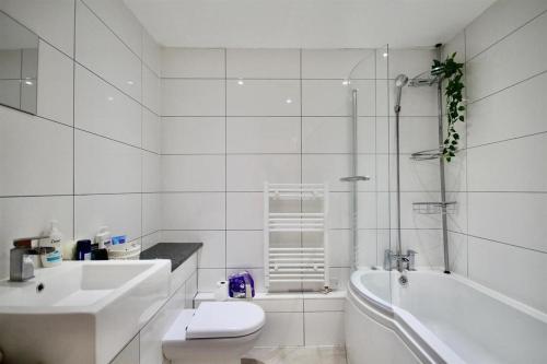 a bathroom with a sink and a toilet and a tub at Wonderful Worthing Beach Walk Flat in Worthing