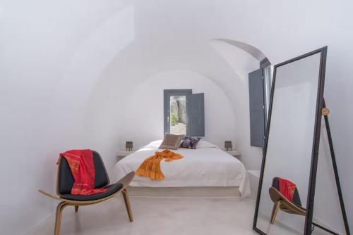 a bedroom with a bed with a mirror and two chairs at Lagadi Suites Mesaria in Mesaria