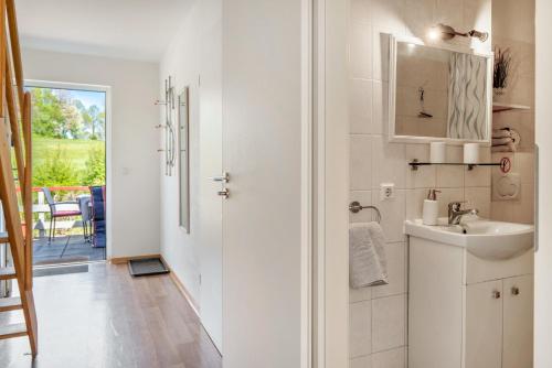 a white bathroom with a sink and a mirror at Ferienapartment Sunshine in Zwinge
