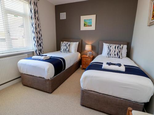 a bedroom with two beds and a window at Castaway Cottage Maidens in Girvan