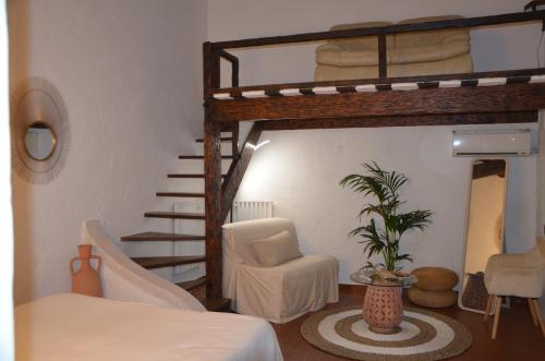 a bedroom with a bunk bed and a chair and a staircase at La Pierrerie in Grimaud