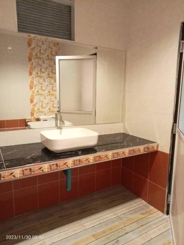 a bathroom with a sink and a mirror at บีฮายฮิลล์ รีสอร์ต in Ban Khlong Kua
