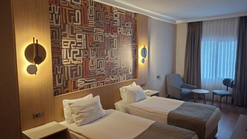 a hotel room with two beds and a painting on the wall at The Green Park Bostancı in Istanbul