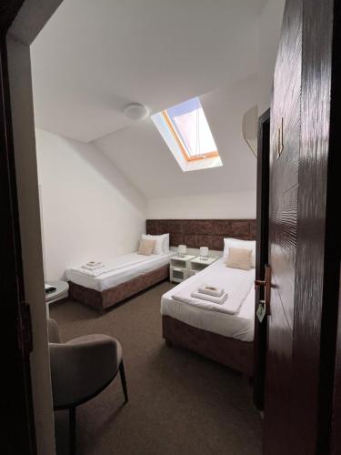 a hotel room with two beds and a skylight at Vila Astonia in Subotica