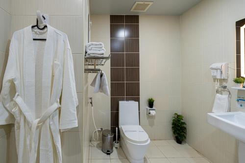 a white bathroom with a toilet and a sink at واحد لواحد للشقق المخدومة -اقتصادي in Al Khobar