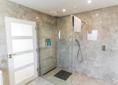 a bathroom with a shower with a glass door at The Summit - Skellig Coast in Cahersiveen