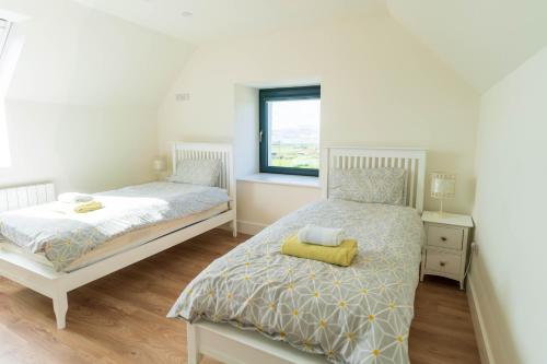 a bedroom with two beds and a window at The Summit - Skellig Coast in Cahersiveen