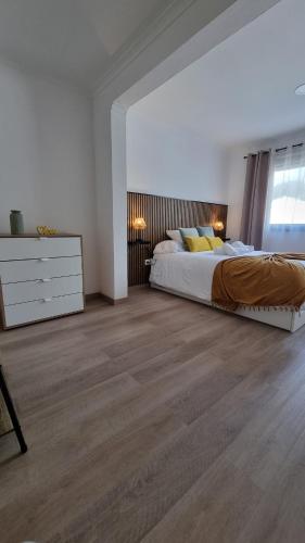 a white bedroom with a bed and a dresser at Mar & Monte in Angra do Heroísmo