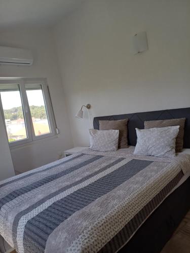 a bedroom with a large bed with a blue and white blanket at Adria in Pašman