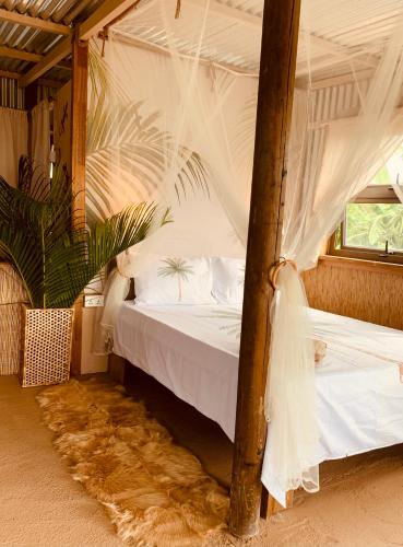 a bedroom with a bed with a canopy at Lotus Lodge Ocean View in Port Mathurin