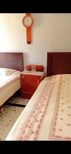 a room with two beds and a clock on the wall at Penthouse Sea Apartment in El Mîna