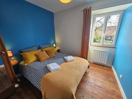 a bedroom with a bed with blue walls and a window at Gite le rémijour in Céaux-en-Couhé