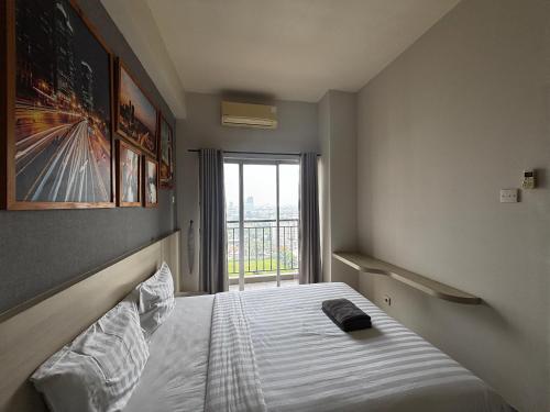 a bedroom with a bed with a large window at Collection O Expressia Stay in Tangerang