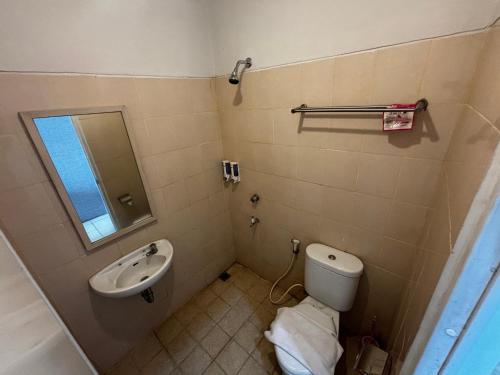 a bathroom with a toilet and a sink at Collection O Expressia Stay in Tangerang