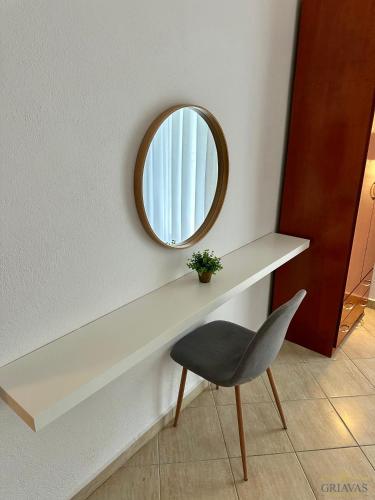a mirror on a wall next to a chair at Griavas at campsite in Sykia Chalkidikis