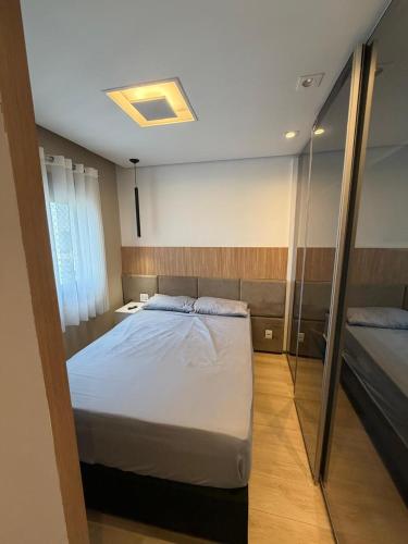 a bedroom with a large bed and a mirror at Piscine Statio Resort Brás in São Paulo