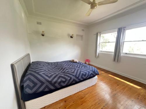 a bedroom with a bed and a ceiling fan at Room51 in Sydney