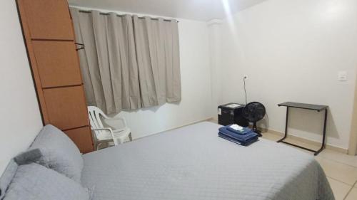 a bedroom with a bed and a table and a chair at Estadia Do Vale Hospedaria União da Vitória in União da Vitória