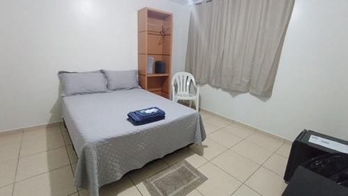 a small bedroom with a bed and a chair at Estadia Do Vale Hospedaria União da Vitória in União da Vitória