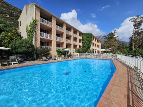 a swimming pool in front of a hotel at Le Marina in Porto Ota