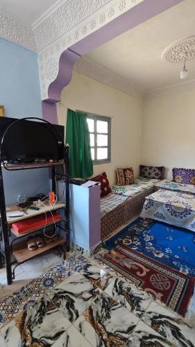 a room with two beds and a table in it at اميزميز in Amizmiz
