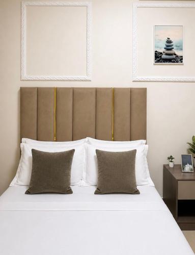 a bedroom with a large bed with white sheets and pillows at Charming apartment limete 1ere rue Kinshasa in Kinshasa