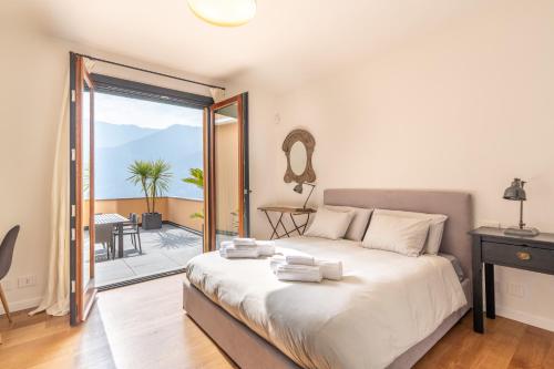 a bedroom with a large bed and a balcony at Lake Como View 3BR Regina 35 in Carate Urio