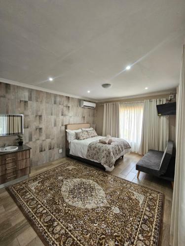 a bedroom with a large bed and a rug at Nolangeni Lodge in Margate