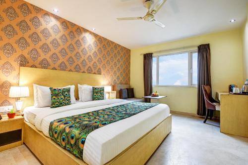 a hotel room with a large bed and a window at Hotel Mayur in New Delhi