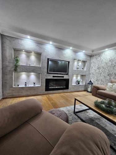 a living room with a couch and a tv at Museum Apartment in Subotica