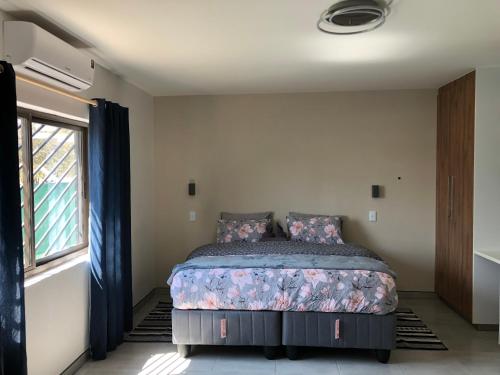 a bedroom with a bed and a window at F2 Homestead in Omuthiya