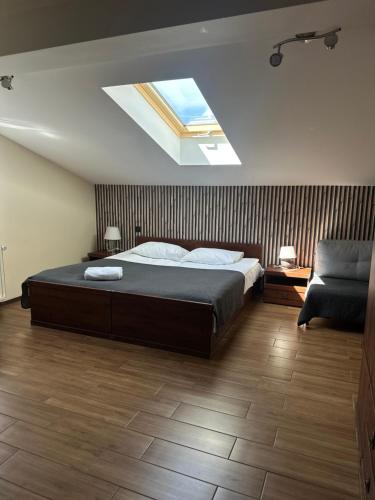 a bedroom with a large bed and a skylight at Pokoje Hotelowe Wiktoria in Goczałkowice Dolne