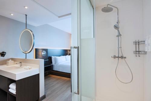 a bathroom with a shower and a sink at AC Hotel by Marriott Georgetown Guyana in Georgetown