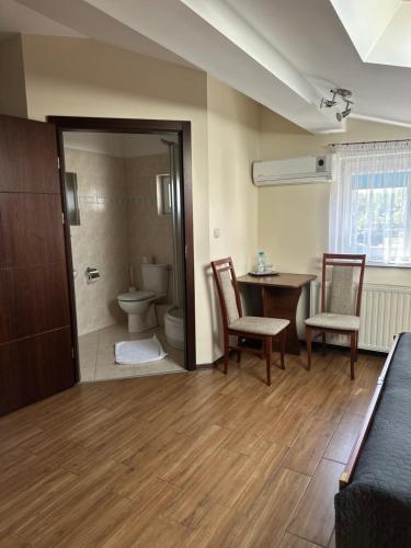 a room with a toilet and a table and chairs at Pokoje Hotelowe Wiktoria in Goczałkowice Dolne