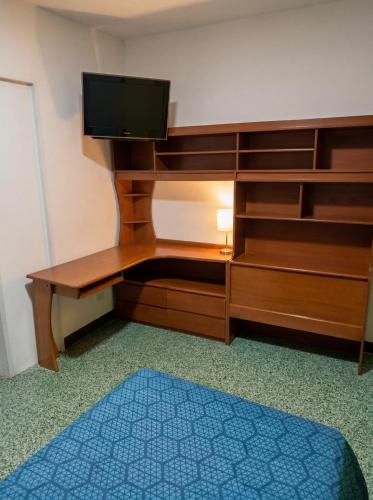 a room with a wooden desk with a television on it at La Milagrosa in Caracas