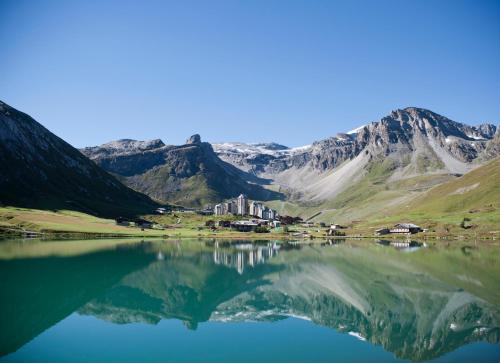a house on the shore of a mountain lake at Langley Hôtel Tignes 2100 in Tignes