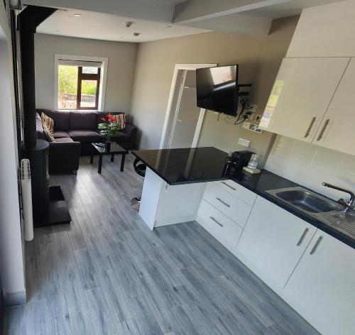 a kitchen and living room with a couch and a table at Ben Breen House Apartment in Crockaunroe