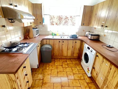 a kitchen with wooden cabinets and a washer and dryer at Room 53 in Sydney