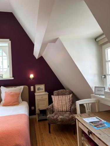 a bedroom with a bed and a table and a chair at Bed & Breakfast Esprit de Mer in De Panne